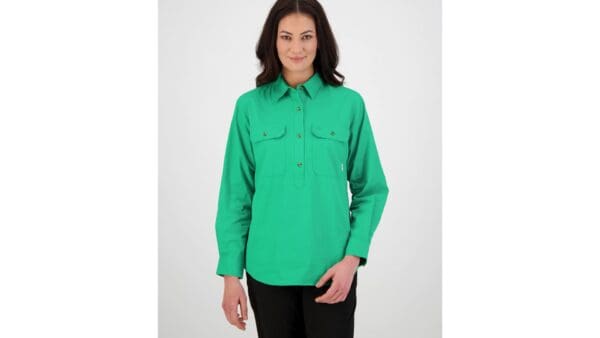 woman standing front on wearing swanndri's women's-roma-long-sleeve-shirt in green. 100% cotton, 152gsm Button flap chest pockets Half placket button opening Centre back box pleat