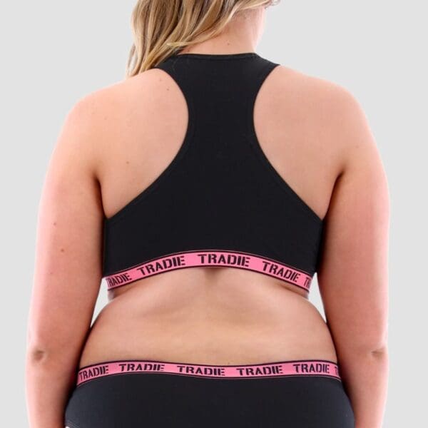 Image of size 18 model wearing Tradie Lady Curve Crop Top. It is black with a pink elastic and a racing back design.