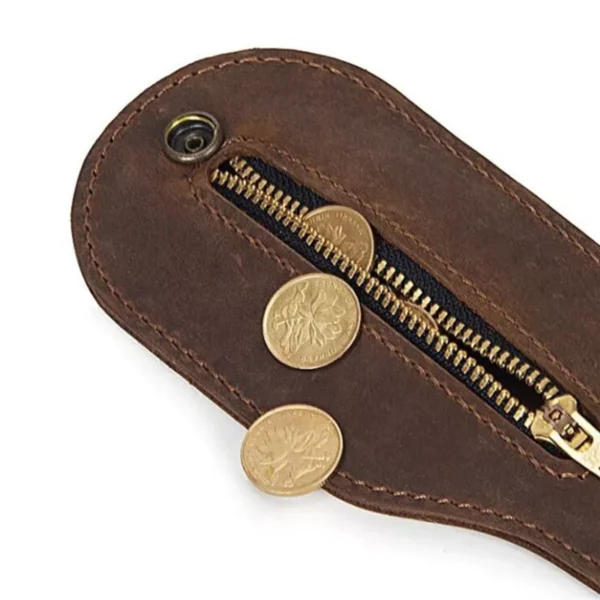 Brown Leather Medication or Coin Purse Belt Wallet. Close-up of a brown leather coin pouch with a zippered pocket partially open, revealing gold coins spilling out.